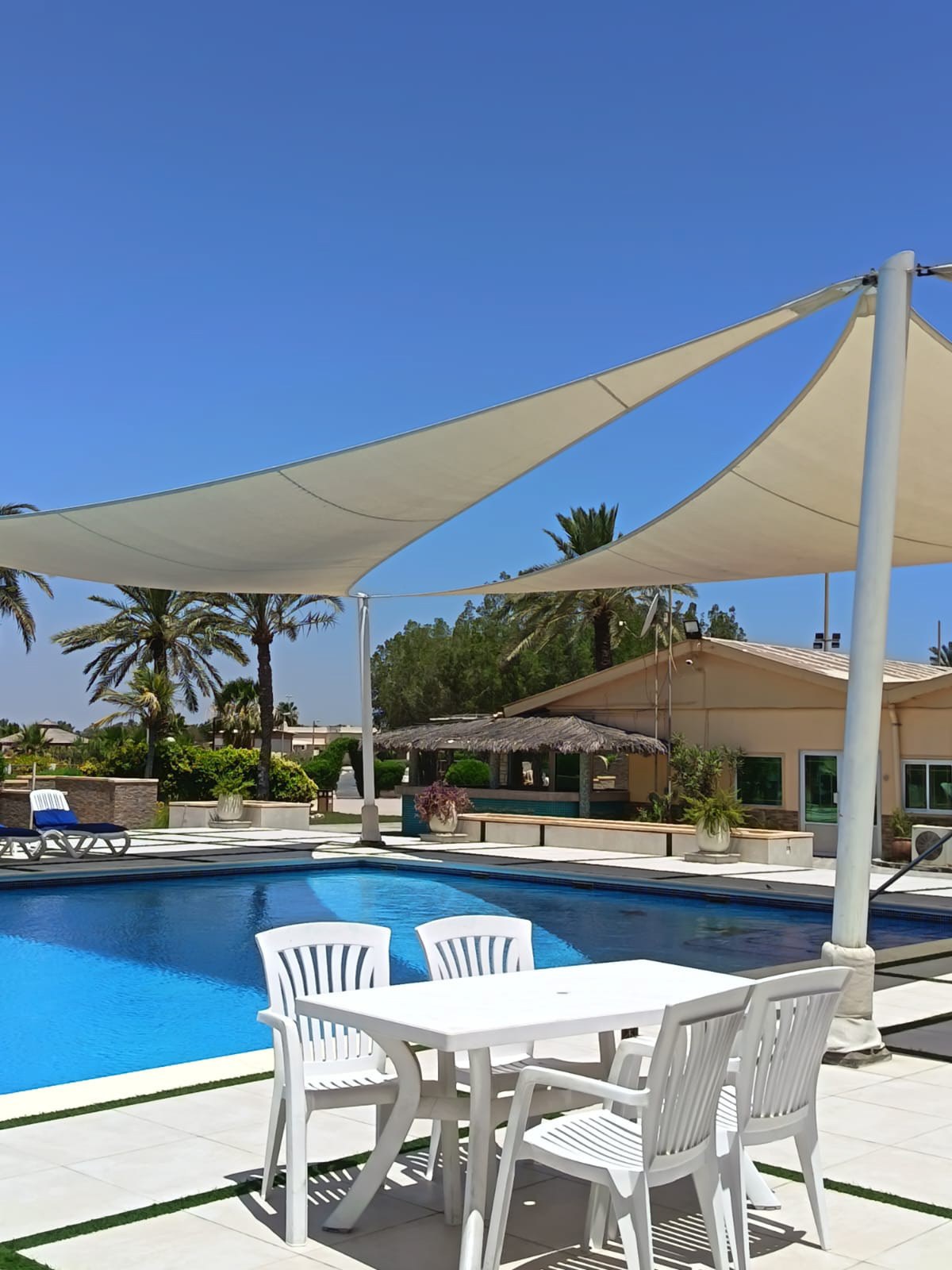 Tensile shade structures beside a swimming pool