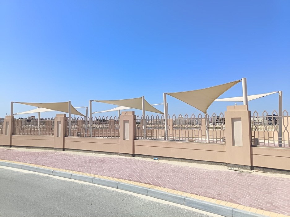 Outdoor tensile shades behind boundary wall